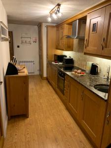 a kitchen with wooden cabinets and a counter top at Willow View, Cartmel in Cartmel