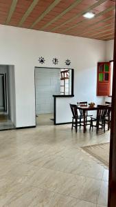a room with a table and chairs in a room with a wall at Casa na Praia do Morro Grande e Muito Arejada in Guarapari