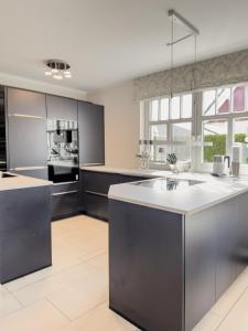 a large kitchen with a large white counter top at Ferienhaus Mee(h)rZeit in Zingst +29 photos