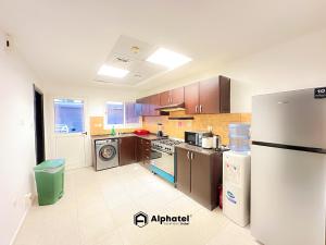 迪拜Stylish 3-bedroom plus Maid room - Villa in JVC - Dubai的厨房配有不锈钢用具和冰箱