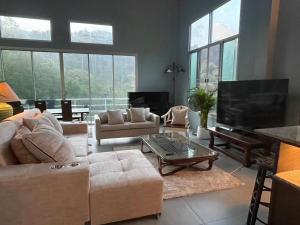 un salon avec un canapé et une télévision dans l'établissement Mon Jam Cottage, à Chiang Mai