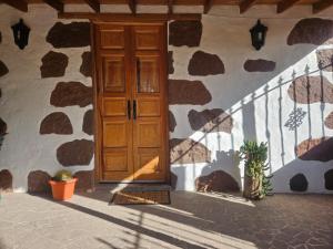 a house with a wooden door and a stone wall at Casa Rosiana in Santa Lucía