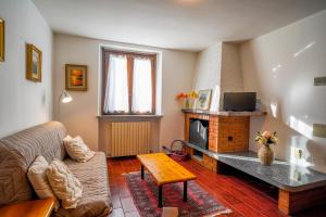 a living room with a couch and a fireplace at La Corte Antica in Cassina Valsassina