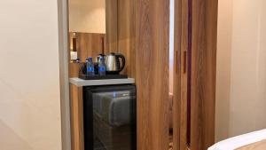 a room with a small refrigerator in a room at هندباء Hindibaa in Al ‘Azīzīyah