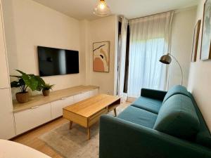 a living room with a blue couch and a tv at Samaniego Apartment - Madrid Airport in Madrid