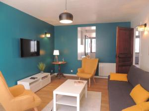 a living room with a couch and a tv at Jolie maison 3 étoiles entièrement rénovée in Fouras