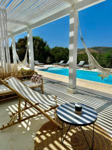 un patio con un'amaca, un tavolo e una piscina di Herdade d'Amoreira Rosmaninho Studio ad Aljezur