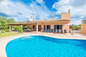 a villa with a swimming pool in front of a house at Villa Canescandeu in Port de Pollensa