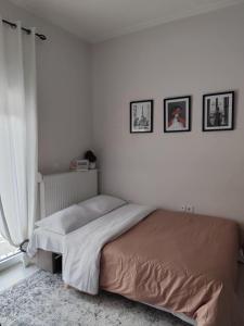 a bedroom with a bed and three pictures on the wall at Lydia's Apartment in Tripolis +6 photos