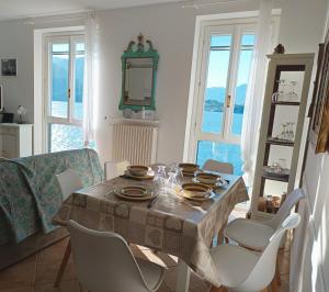 a dining room with a table and white chairs at Camilla House in Varenna