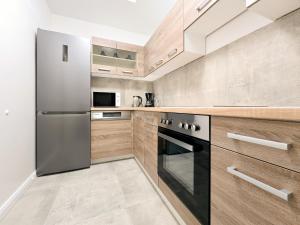 a kitchen with stainless steel appliances and wooden cabinets at Tolstov Apartments - 2 Room Apartment - 25 min Messe DUS in Duisburg +13 photos