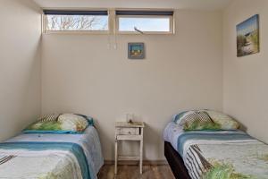two twin beds in a room with a window at Vakantiehuisje in Ouddorp dichtbij het strand in Ouddorp