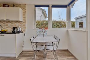 a kitchen with a table and chairs in a kitchen at Vakantiehuisje in Ouddorp dichtbij het strand in Ouddorp