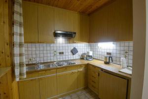 a kitchen with wooden cabinets and a sink at Appartement Alpenblick in Valdaora +22 photos