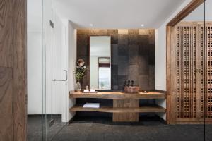 a bathroom with a sink and a mirror at Tengchong Bodu Hot Spring Resort Hotel in Tengchong