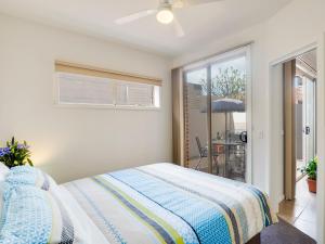 a bedroom with a bed and a balcony with an umbrella at McKillop Geelong by Gold Star Stays in Geelong