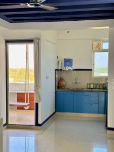 cocina con armarios azules y techo en Lotus Diamerisma - 2BHK Furnished Apartment in Jodhpur - Peaceful Retreat Away from City Traffic, en Jodhpur