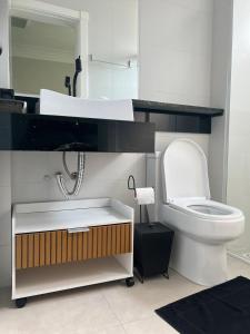 a bathroom with a white toilet and a mirror at Apto 3 Suítes e Garagem Dupla Itapema Meia Praia em Ótima Localização in Itapema