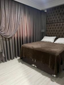 a bedroom with a large bed in a room with curtains at Apto 3 Suítes e Garagem Dupla Itapema Meia Praia em Ótima Localização in Itapema