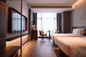 a hotel room with two beds and a tv at UrCove by HYATT Shantou Zhugang New Town in Shantou +26 photos