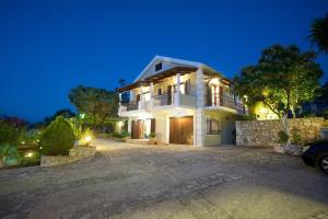a large white house at night with a driveway at Casa Nobile in Lavonikés