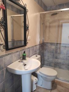 a bathroom with a sink and a toilet and a mirror at Casa en Guadalcanal in Guadalcanal