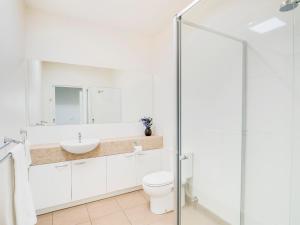 a bathroom with a toilet, sink and shower at McKillop Geelong by Gold Star Stays in Geelong