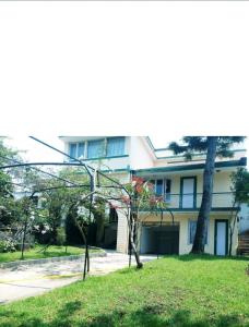 a house with a tree in front of it at Green Woods Homestay in Kodaikānāl