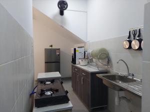 a small kitchen with a stove and a sink at Ammar Homestay Nilai in Nilai