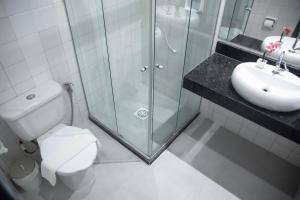 a bathroom with a shower and a toilet and a sink at Hotel Praia do Morro in Guarapari +48 photos