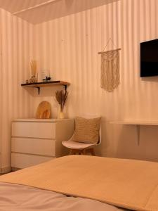 a bedroom with a bed and a chair and a shelf at Boho City Livings Munich Central Station in Munich