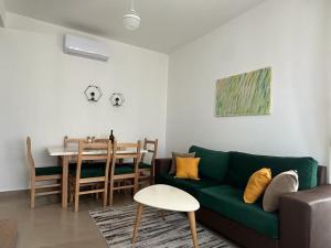 a living room with a green couch and a table at Valamar Cozy Apartment in Hamallë