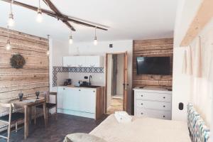 a kitchen and dining room with wooden walls and a kitchen with a table at Willa Belmont in Zakopane