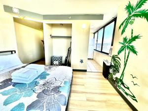 a bedroom with a bed and a palm tree mural at Ocean Canal Mountain View Steps from Waikiki Beach 6person in Honolulu +30 photos