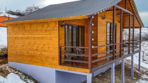 a wooden cabin with a roof on a deck at Grili Chero in Dushetʼi