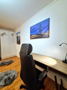 a desk with a chair and a picture on the wall at Stavanger Sea 1 Ultra Central Dali Apartament General Shop Open 7 l 7 in Stavanger