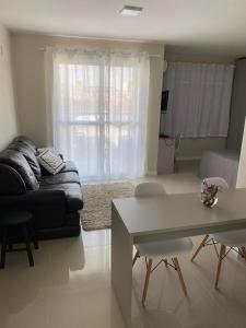 a living room with a couch and a table at Loft central com garagem in Pelotas