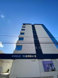 a building with a sign that reads single resilience at Loft central com garagem in Pelotas