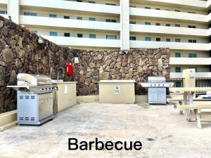 a patio with a counter and a stone wall at Ocean Canal Mountain View Steps from Waikiki Beach 6person in Honolulu
