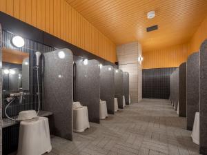a bathroom with a row of urinals and toilets at APA Hotel & Resort Osaka Namba Ekimae Tower in Osaka