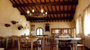 jadalnia ze stołami i krzesłami oraz żyrandolem w obiekcie Agriturismo Fattoria Rozzalupi w mieście Cerreto Guidi