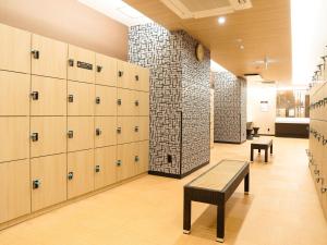 a locker room with lockers and a bench in it at APA Hotel & Resort Osaka Namba Ekimae Tower in Osaka