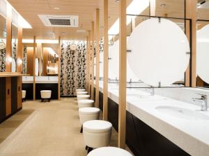 a bathroom with a row of sinks and toilets at APA Hotel & Resort Osaka Namba Ekimae Tower in Osaka