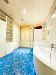 bagno con pavimenti blu e vasca. di Amazing 4BR Shared Apartment 10 Minute Walk to FAC Platz a Vienna
