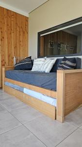 a large bed with a wooden frame in a bedroom at Aire de Chapelco in San Martín de los Andes