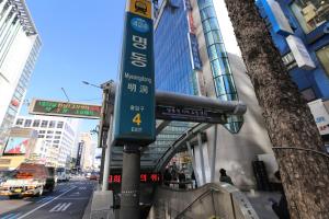 a street sign on a pole on a city street at Philstay Myeongdong Boutique Female in Seoul