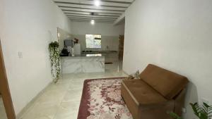 a living room with a couch and a kitchen at Casa 5 minutos da praia in Santa Cruz Cabrália +8 photos
