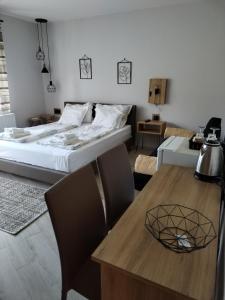 a bedroom with a bed and a table with chairs at Guest House Dimitrije in Niška Banja