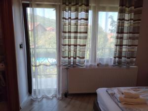 a bedroom with a bed and a large window at Guest House Dimitrije in Niška Banja