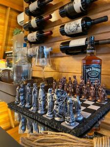 a chess board and bottles of wine on a wall at Cabana Santo Rancho Treze Tílias in Treze Tílias
